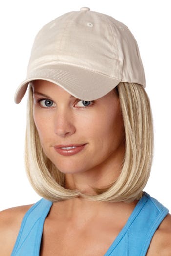 Woman in a solid beige baseball cap with shoulder length curled under light ash blonde hair attached