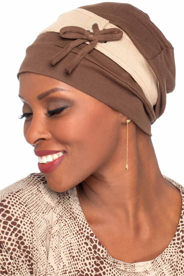 Woman in a slouchy snood style burgundy chemo turban with laces and bow on the side