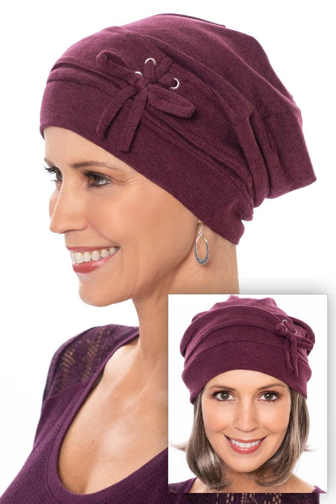 Woman in a slouchy snood style burgundy chemo turban with laces and bow on the side