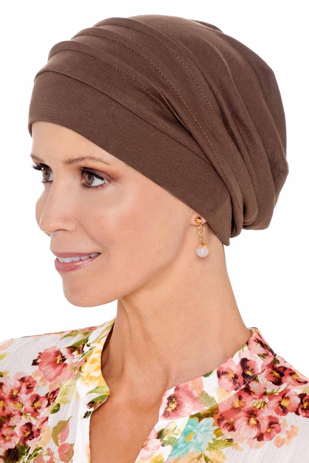 Woman with flowered shirt in brown snood head covering