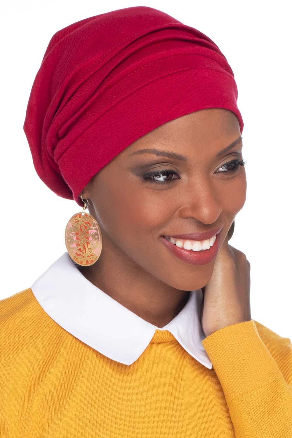 Smiling woman wearing red slouchy snood hat for cancer patients