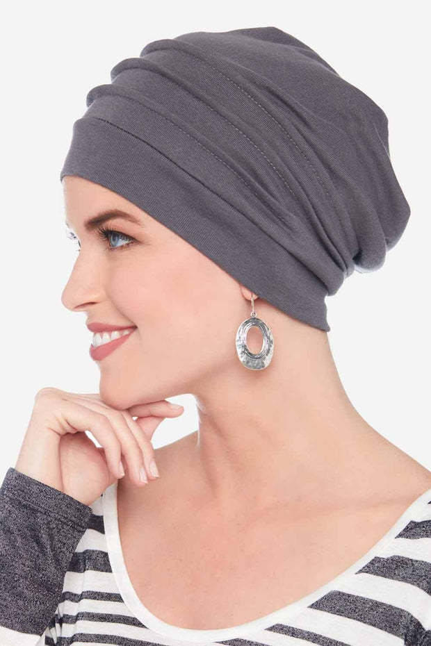 Women wearing grey slouchy beanie hat for cancer patients with pleats and loose fit